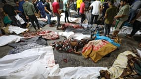 Des personnes se rassemblent autour des corps de Palestiniens tués lors des frappes aériennes israéliennes sur l'hôpital arabe Ahli, dans le centre de Gaza, après leur transport à l'hôpital Al-Shifa, le 17 octobre 2023. Les frappes aériennes israéliennes sur un hôpital de Gaza le 17 octobre ont tué au moins 200 personnes. , a déclaré le ministère de la Santé du territoire palestinien contrôlé par le Hamas, tandis qu'un porte-parole de l'armée israélienne n'a pas confirmé dans l'immédiat que ses forces ont bombardé l'hôpital.