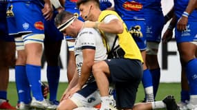 Le talonneur français de Montpellier, Guilhem Guirado (C), reçoit des soins médicaux pendant le match de la finale du Top14 français de rugby à XV entre le Castres Olympique et le Montpellier Hérault Club au Stade de France à Saint-Denis, au nord de Paris, le 24 juin 2022.