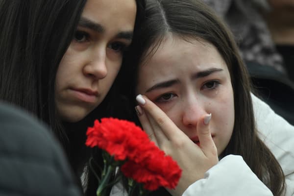 Deux jeunes femmes venues se recueillir devant le mémorial improvisé pour les morts de l'attaque à Moscou, au Crocus City Hall, en Russie