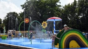 Des enfants se rafraîchissent sur un terrain de jeux à valenciennes, le 27 juillet 2018