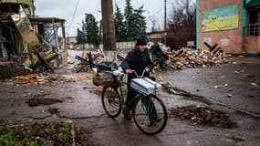 Un homme à vélo au milieu des décombres en Ukraine, le 6 janvier 2022
