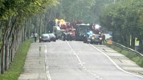 Des policiers et une dépanneuse sur le site d'un accident impliquant une voiture et un bus, le 28 juillet 2023 à Mézières-sur-Seine, dans les Yvelines.