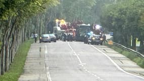 Des policiers et une dépanneuse sur le site d'un accident impliquant une voiture et un bus, le 28 juillet 2023 à Mézières-sur-Seine, dans les Yvelines