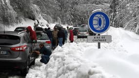 Des automobilistes contraints de mettre leurs chaînes sur la route de Beaufort dans les Alpes, le 30 décembre 2017