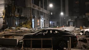 Un habitant marche dans la cour d'un immeuble résidentiel endommagé à la suite d'une attaque de drone à Kiev, le 29 novembre 2025