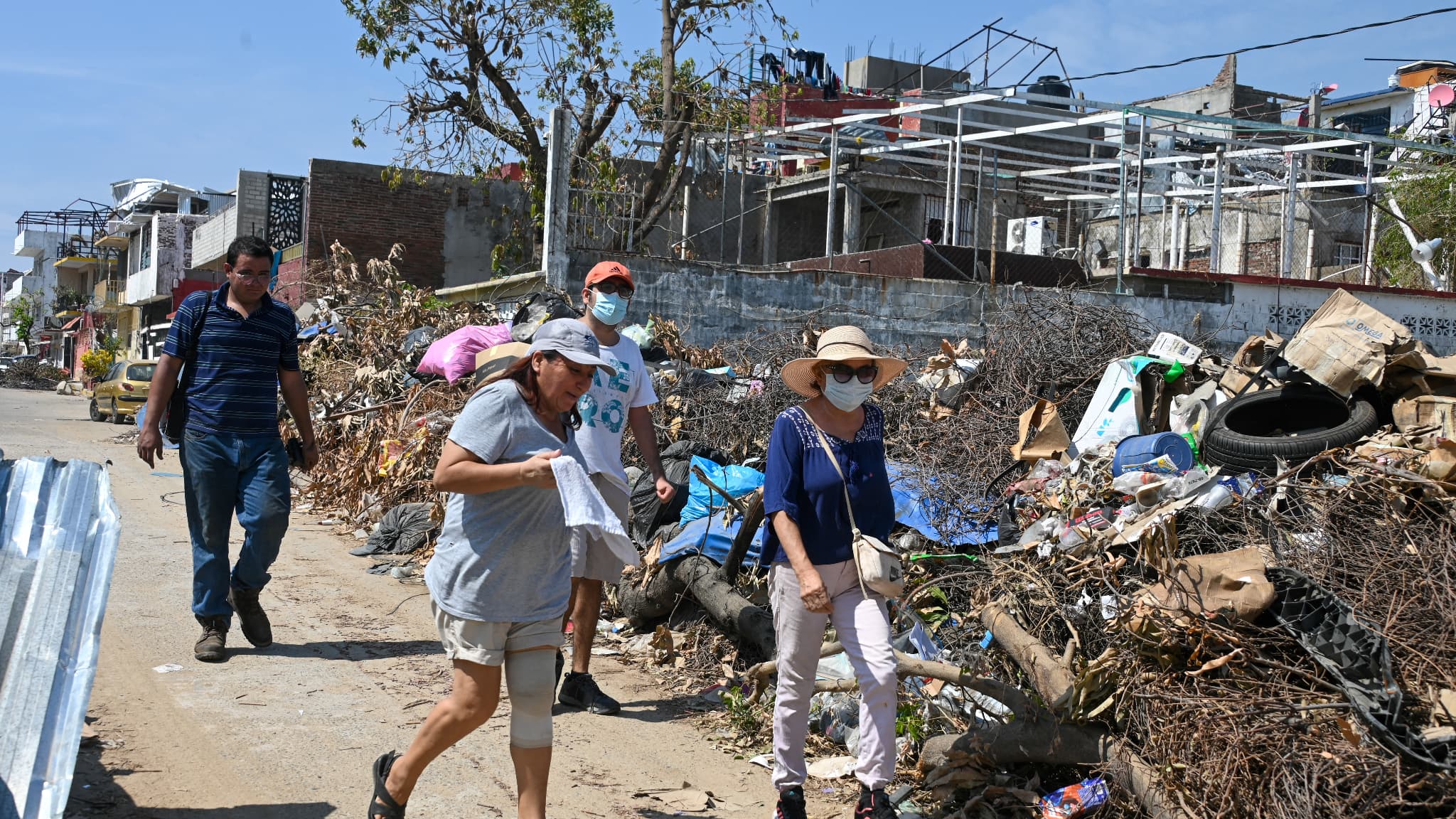 Des habitants d'Acapulco portent des masques en raison de l'augmentation des mauvaises odeurs causées par l'amoncellement d'ordures et de débris après le passage de l'ouragan Otis à Acapulco, dans l'État de Guerrero, au Mexique, le 6 novembre 2023.