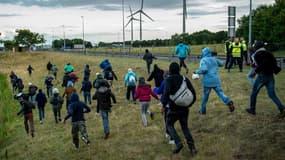 Des migrants tentant de passer les barrages de police installés près de Calais