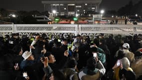 Des manifestants devant la porte principale de l'Assemblée nationale à Séoul, en Corée du Sud, le 4 décembre 2024