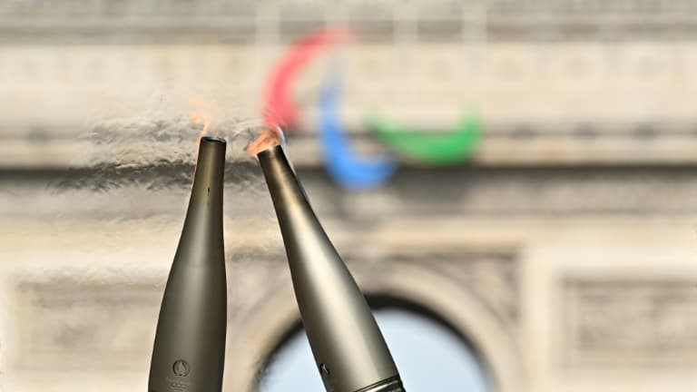 La flamme olympique sur les Champs-Elysées, avec en fond l'Arc de Triomphe, le 15 juillet 2024 à Paris.