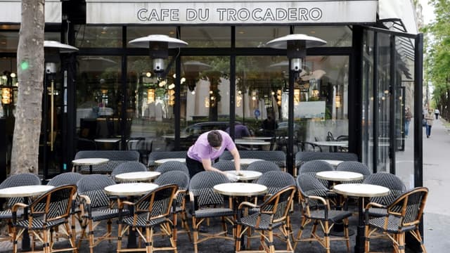 Un employé nettoie les tables en terrasse au "Café du Trocadéro", le 11 mai 2021 à Paris, avant la réouverture des bars et restaurants le 19 mai