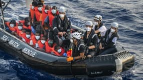 Des migrants du bateau Louise Michel, affrété par l'artiste de rue Banksy, sont emmenés par des membres d'équipage du bateau humanitaire Sea-Watch 4 lors d'une opération de secours, le 29 août 2020 au large des côtes maltaises