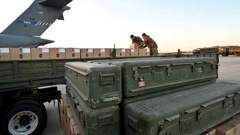Des caisses empilées de missiles sol-air Stinger de fabrication américaine (au premier plan), devant des soldats ukrainiens chargeant de l'équipement sur un camion, à l'aéroport de Kiev, le 13 février 2022. PHOTO D'ILLUSTRATION
