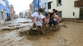 Des habitants dans une rue inondée de Trujillo, à 570 km au nord de Lima, le 18 mars 2017