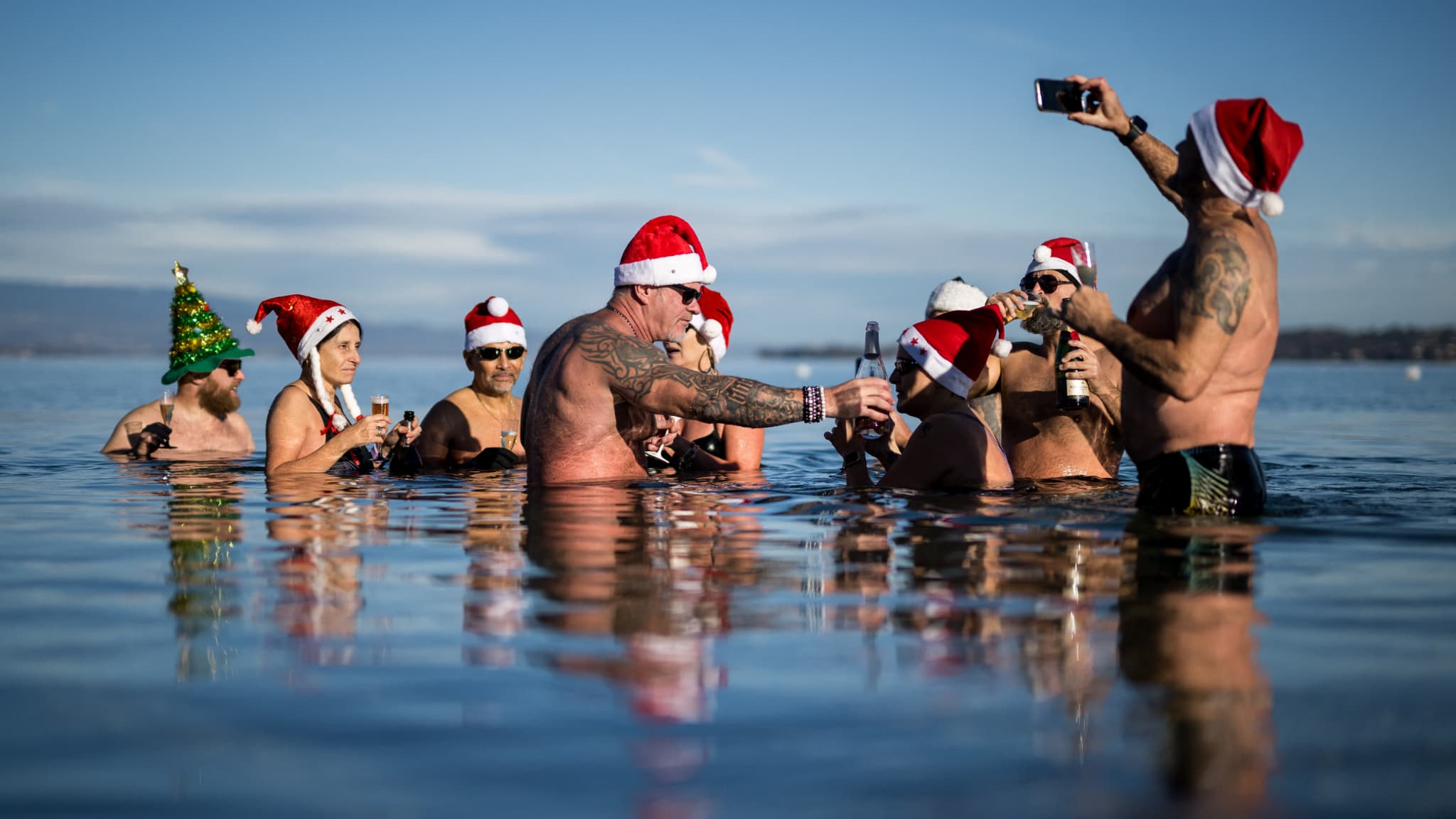 Des baigneurs dans le lac Léman, dans une eau à 8°C, aux Bains des Paquis, au centre-ville de Genève, en Suisse, le 24 décembre 2023.