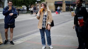 Des clients d'un pub à Londres boivent leur bière dans des verres en plastique à l'extérieur de l'établissement, en raison des restrictions contre le coronavirus alors en vigueur, le 5 juin 2020
