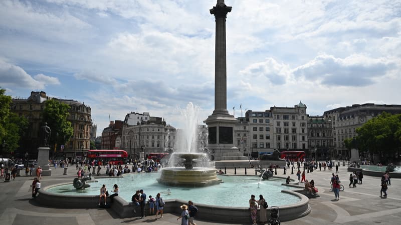 Des passants se rafraîchissent à la fontaine de Trafalgar Square à Londres, au Royaume-Uni, sous le coup d'un épisode de canicule, le 13 juillet 2022