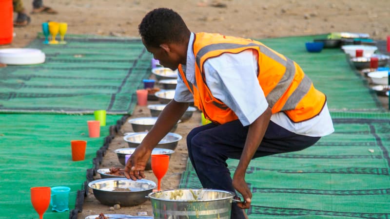Un bénévole dispose de la nourriture dans des assiettes pour les musulmans déplacés à l'intérieur du pays qui rompent le jeûne pendant le mois du Ramadan à Gedaref, au Soudan, le 13 mars 2024.