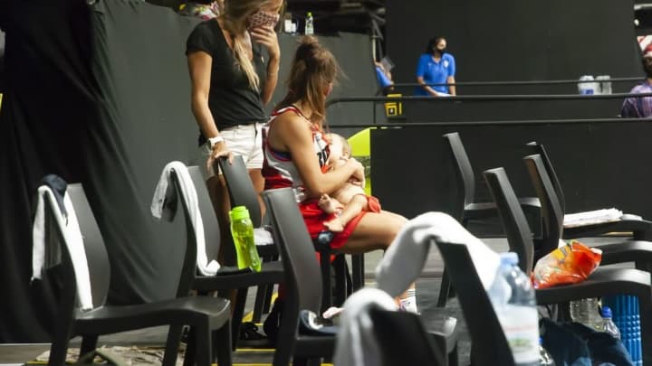 Une joueuse allaite son bébé pendant un match