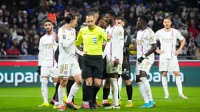 Maxence Caqueret discute avec l'arbitre Jérôme Brisard lors de Lyon-Lens (0-3, L1), le 3 mars 2024