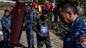 Un homme porte le portrait d'un soldat mort au combat dans la région séparatiste du Haut-Karabakh, le 17 octobre 2020.