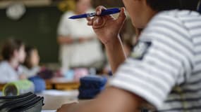 Un élève tient son stylo dans sa main (photo d'illustration)