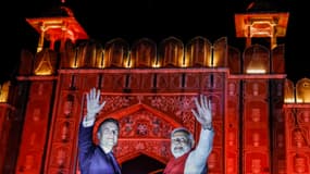 Le Premier ministre indien Narendra Modi (à droite) et le président français Emmanuel Macron se saluent depuis le haut d'un véhicule à Jaipur, le 25 janvier 2024.