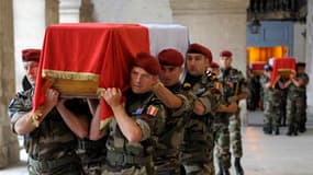 Des militaires français portent dans l'église Saint-Louis des Invalides les cercueils des sept soldats français tués la semaine dernière en Afghanistan, auxquels a été rendu un hommage national mardi matin. /Photo prise le 19 juillet 2011/REUTERS/Philippe