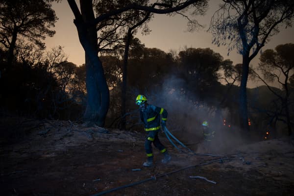Des pompiers tentent d'éteindre un feu de forêt à Puerto Real, près de Cadix en Espagne, le 6 août 2023.