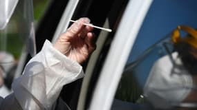 Un biologiste pratique un test coronavirus dans un drive-in à Plabennec (ouest), le 20 juillet 2020
