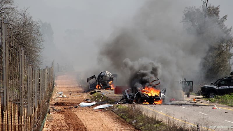 Des véhicules militaires israéliens brûlent après une attaque près de la fontière israélo-libanaise.