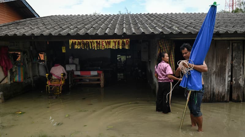 Des habitants les pieds dans l'eau après le passage de la tempête Pabuk à Nakhon Si Thammarat en Thaïlande, le 5 janvier 2019