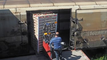 Un employé charge des cagettes de fruits dans un train pour le marché de Rungis le 14 mai 2019 à Perpignan