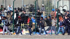 Des policiers délogent des migrants de leur camp situé à Calais le 2 juillet 2014