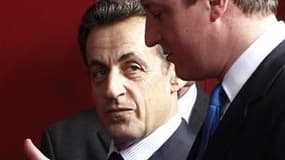 Nicolas Sarkozy et le Premier ministre britannique David Cameron. La France et la Grande-Bretagne ont décidé de réclamer la tenue d'un conseil européen pour discuter de la situation en Libye. /Photo prise le 16 décembre 2010/REUTERS/Thierry Roge