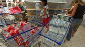 Des personnes achetant de l'eau dans un supermarché.