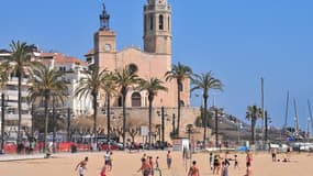 Des jeunes gens en train de jouer au beach volley sur une plage de Sitges, près de Barcelone.