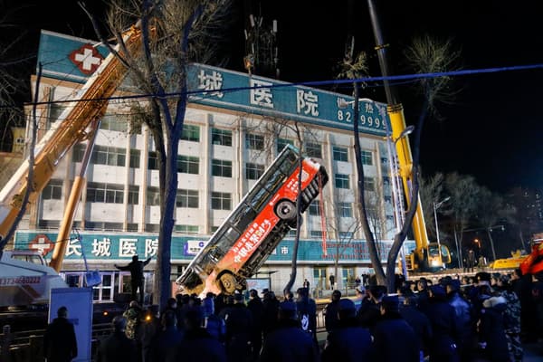 Les équipes de secours chinoises remontent le bus qui a été presque englouti par un trou dans la chaussée, le 13 janvier 2020 à Xining, en Chine Les équipes de secours chinoises remontent le bus qui a été presque englouti par un trou dans la chaussée, le 13 janvier 2020 à Xining, en Chine