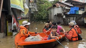 Cette photo prise et publiée le 4 novembre 2025 montre des membres des garde-côtes évacuant des personnes de leurs maisons inondées à la suite du typhon Kalmaegi dans la province de Cebu, au centre des Philippines.