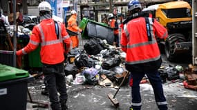 Des entrepreneurs privés collectent des déchets sur un trottoir à Paris, le 30 mars 2023. (Photo d'illustration)