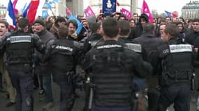 Des gendarmes tentant de contenir des manifestants près de la place de l'Etoile, dimanche.