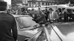 Des policiers entourant la voiture criblée de balles de Jacques Mesrine en 1979 à Paris. 
