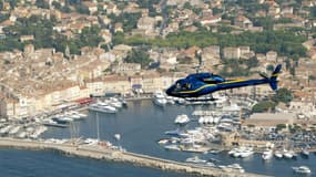 Un hélicoptère transportant un groupe de touriste survol le port de Saint-Tropez, le 30 juin 2006.