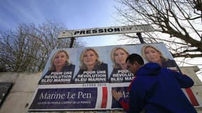 Un partisan du Front national colle des affiches de campagne de Marine Le Pen à Hénin-Beaumont. Dans cette ville de l'ancien bassin minier du Pas-de-Calais, qui sert de "laboratoire électoral" à Marine Le Pen et où s'élèvent encore des terrils, les proche