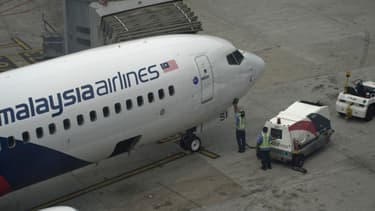 Un avion de la Malaysia Airlines est inspecté sur le tarmac de l'aéroport de Kuala Lumpur, le 13 mars 2014.