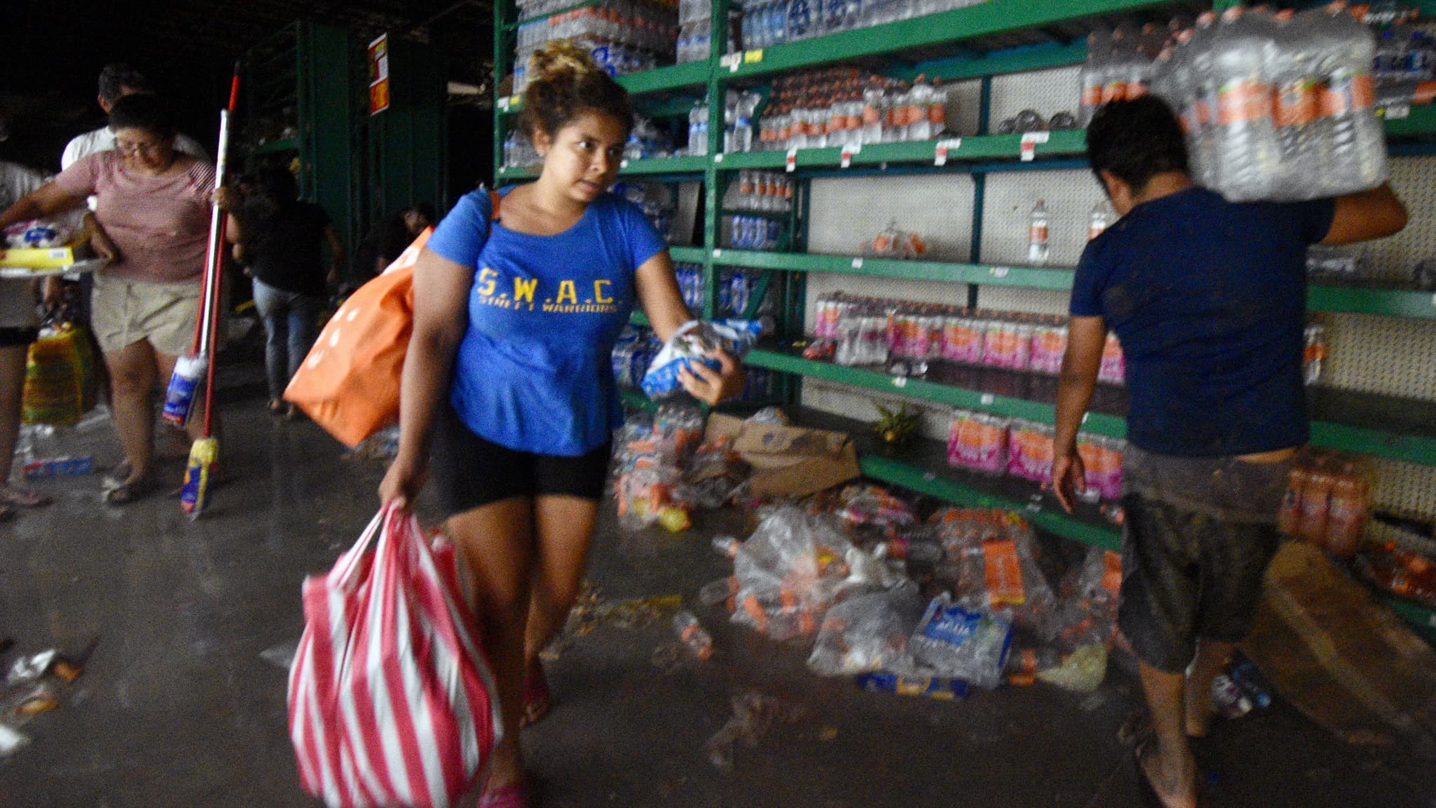 Des personnes font leurs courses dans un supermarché pillé après le passage de l'ouragan Otis à Acapulco, dans l'État de Guerrero, au Mexique, le 25 octobre 2023