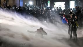 Les forces de l'ordre tentent de maîtriser des manifestants à l'aide d'un canon à eau, le 21 novembre 2020, à Paris