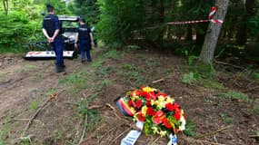 Des policiers passent devant le site présumé où se trouvent les dépouilles de 47 soldats allemands et d'une Française accusée de collaboration, exécutés en juin 1944 par la résistance locale, à Meymac, en Corrèze, le 27 juin 2023.