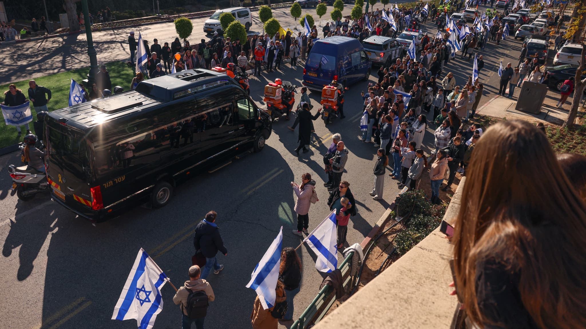 Los israelíes se reúnen alrededor de la procesión fúnebre que transporta los restos de la familia Bibas en Rishon LeZion el 26 de febrero de 2025