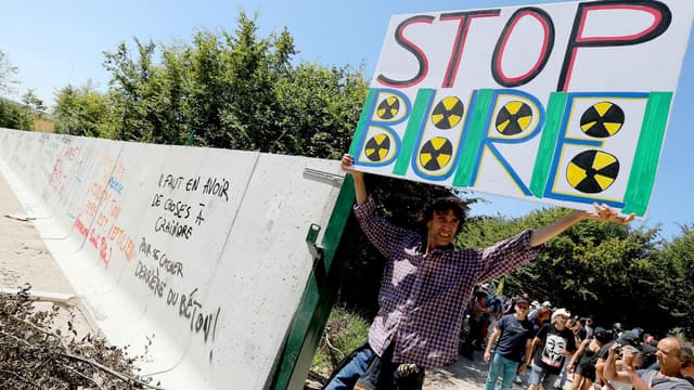 Un homme portant une pancarte sur le site de Bure, où doit être installé un site d'enfouissement de déchets nucléaires, le 14 août 2016.