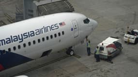 Un avion de la Malaysia Airlines est inspecté sur le tarmac de l'aéroport de Kuala Lumpur, le 13 mars 2014.